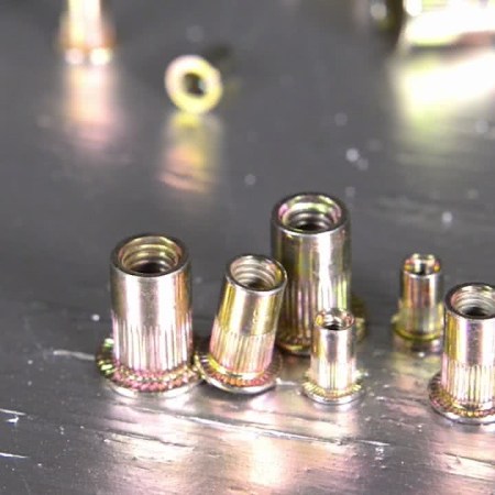 Assortment of rivet nuts on a metal surface highlighting different sizes for industrial use in Australia.